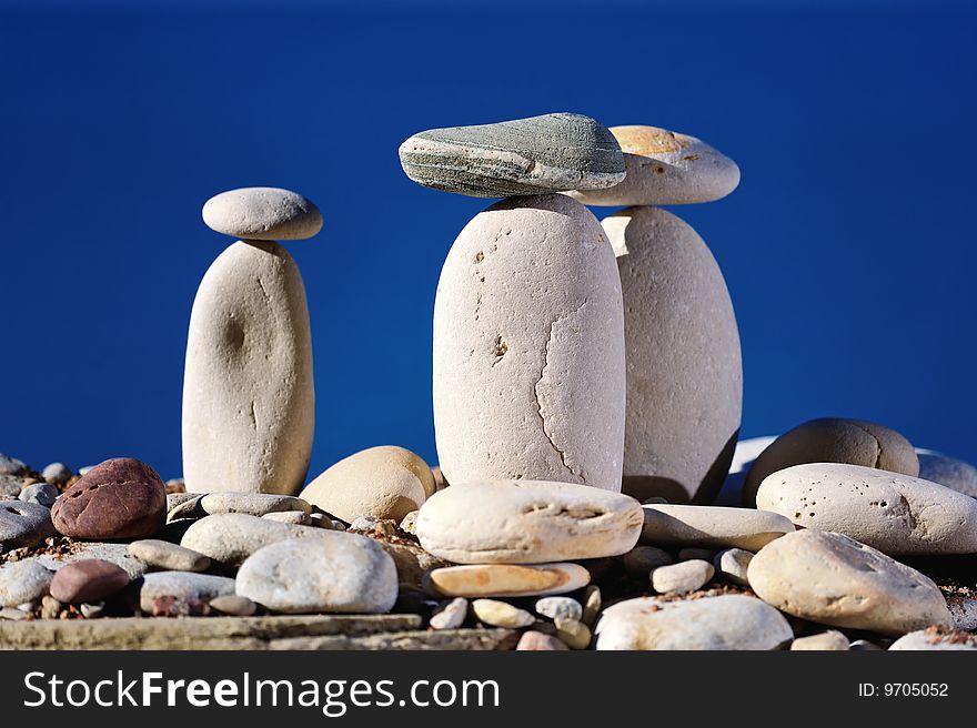 Long white pebbles on a background of blue sky. Long white pebbles on a background of blue sky