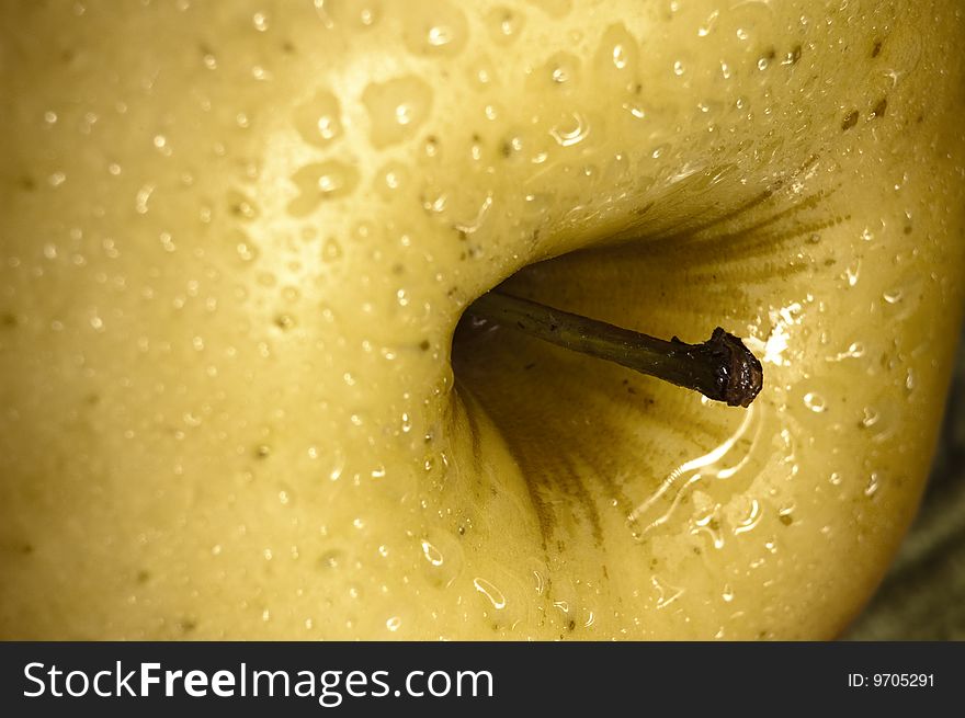 Close up shot of a yellow apple with some drops of water