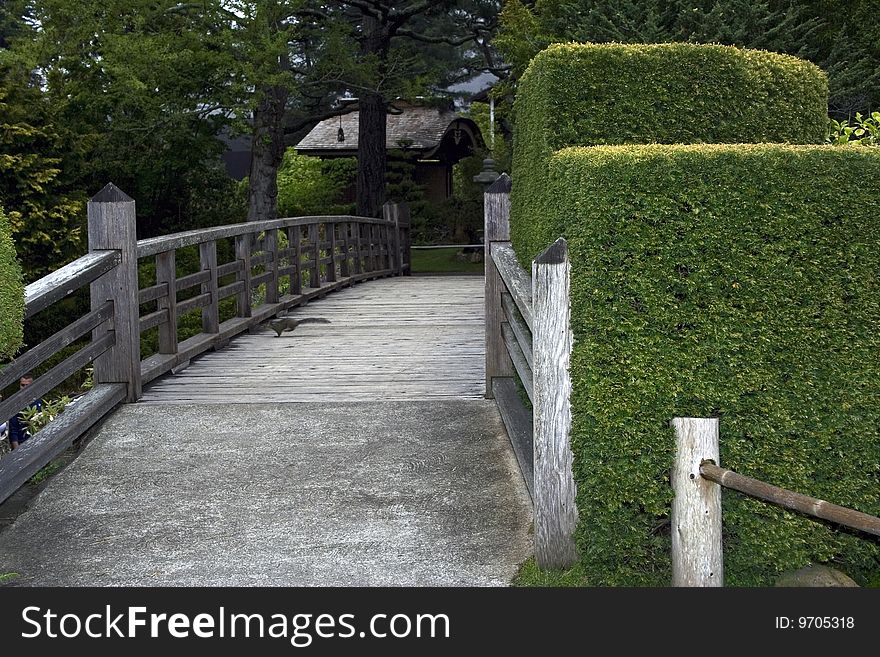 Nice wooden bridge with the running squirrel in a japanese garden