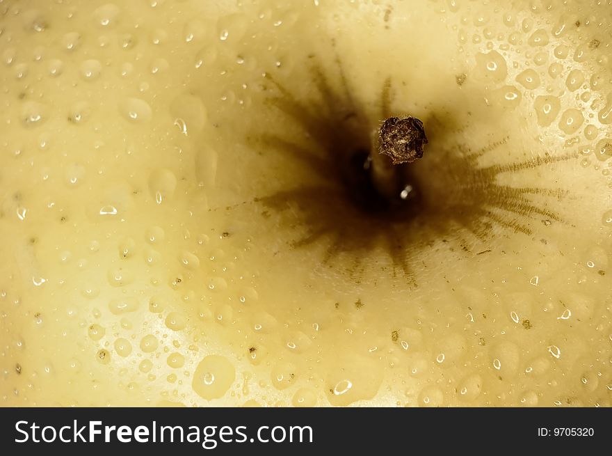 Close up shot of a yellow apple with some drops of water