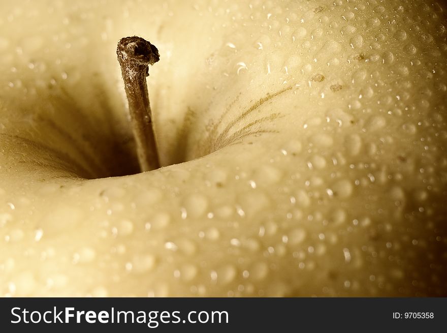 Close up shot of a yellow apple with some drops of water