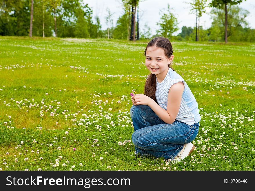 Girl sits on a green grass with flowers. Girl sits on a green grass with flowers