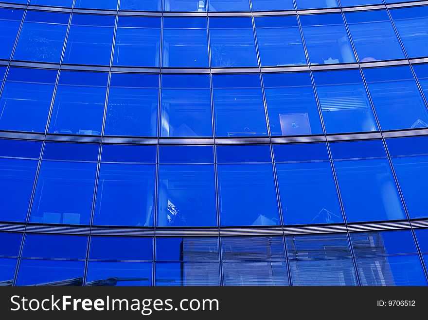 The blue background of the office building with windows. The blue background of the office building with windows