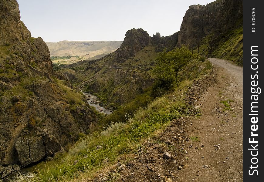 Narrow mountain path, River in valley. Summer day in Georgia. Caucasus