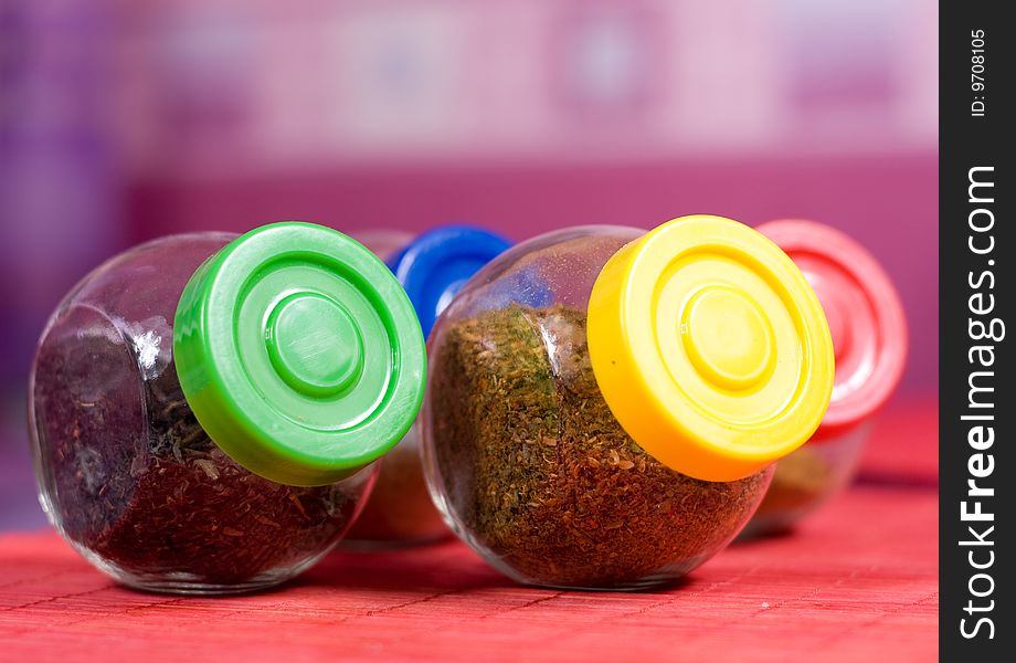 Four glass jars with spices and color covers