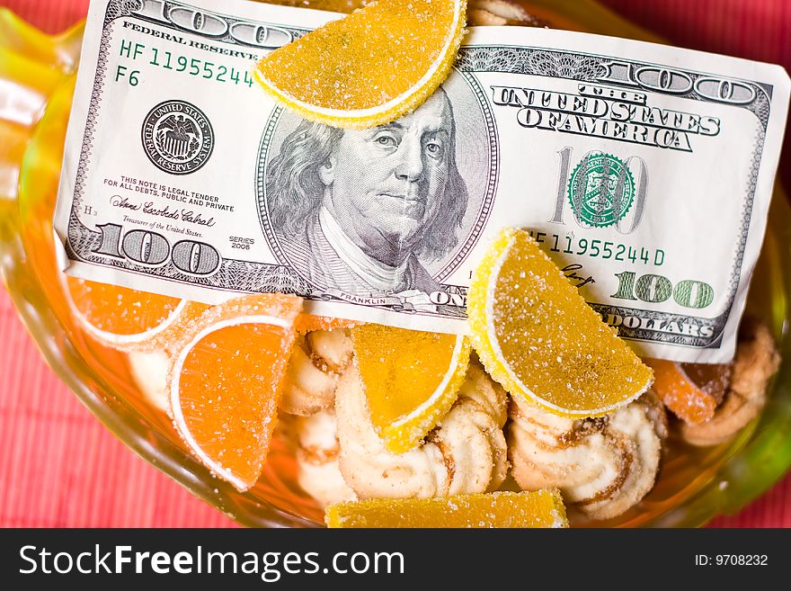 Paper money in bowl  with fruit jelly and sweet cookies. Paper money in bowl  with fruit jelly and sweet cookies