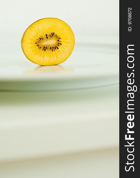 A sliced golden yellow Kiwi on a plate. A sliced golden yellow Kiwi on a plate.