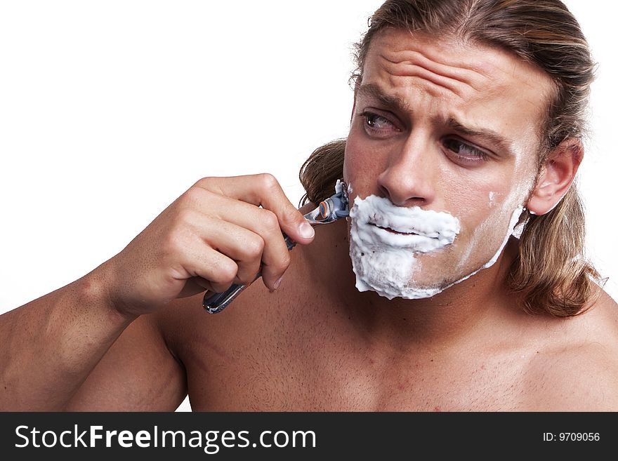 Portrait of a young handsome man shaving as part of his morning routine. Portrait of a young handsome man shaving as part of his morning routine.