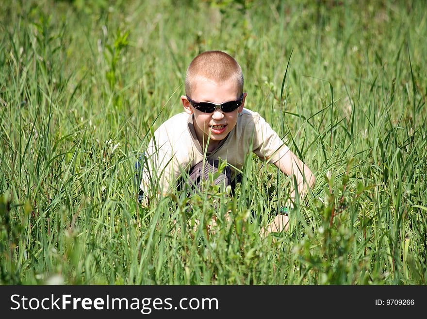 The boy in a grass on the nature plays security service