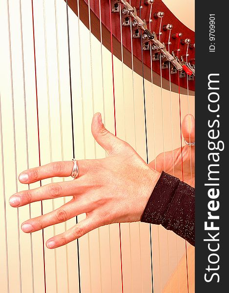Hands closeup of Woman musician playing a harp