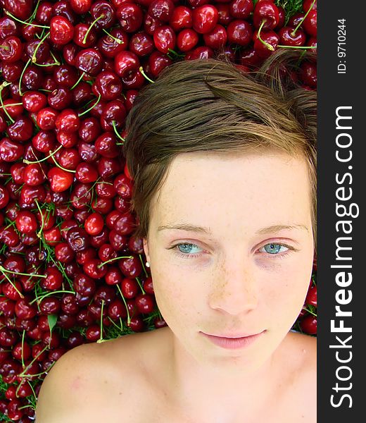 Blue eyed young girl on a bed of cherries. Blue eyed young girl on a bed of cherries