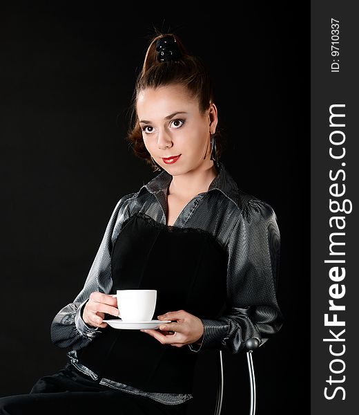 Portrait of young girl who sits and keeps white cup. Portrait of young girl who sits and keeps white cup