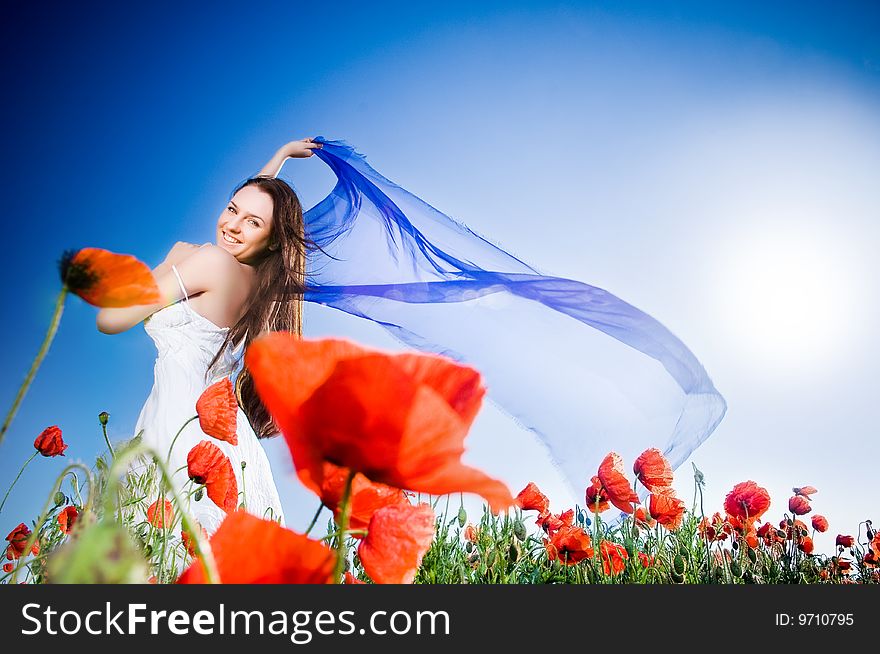 Beautiful girl in the poppy field, low angle view