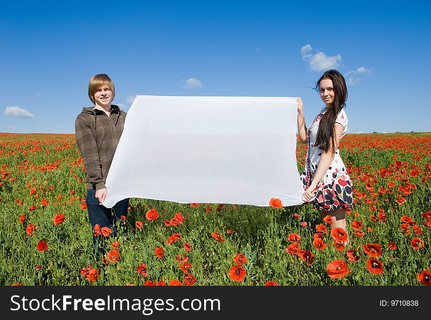 Beautiful couple in the poppy field, copy-space for your text