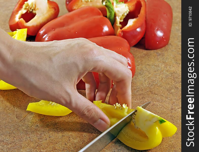Female hands cut multi-coloured pepper. Female hands cut multi-coloured pepper
