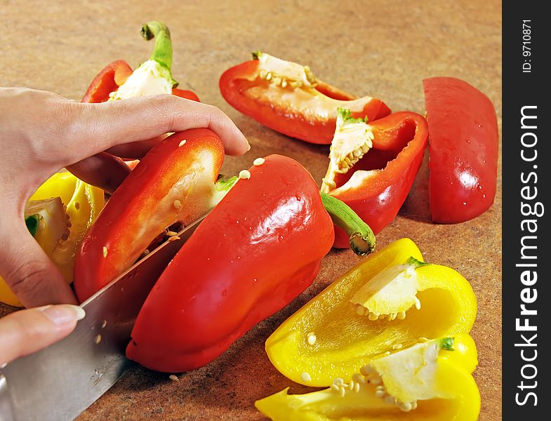 Female hands cut multi-coloured pepper. Female hands cut multi-coloured pepper