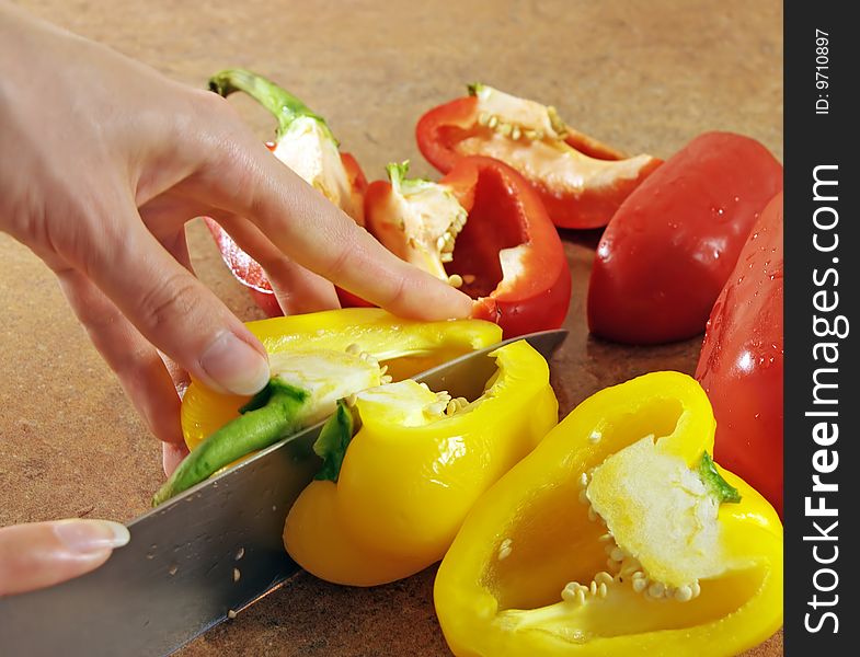 Female hands cut multi-coloured pepper. Female hands cut multi-coloured pepper