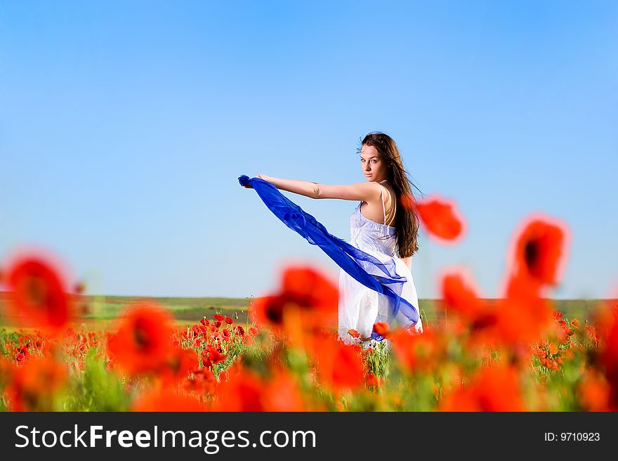 Attractive girl with blue scarf in the poppy field. Attractive girl with blue scarf in the poppy field