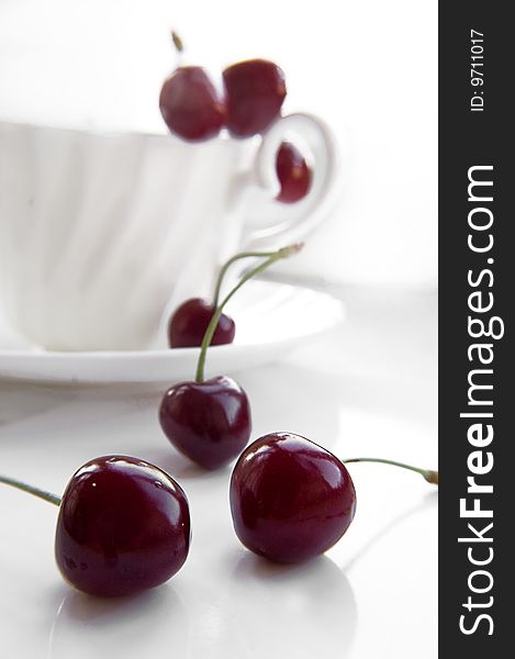 Some cherries in cup over white background