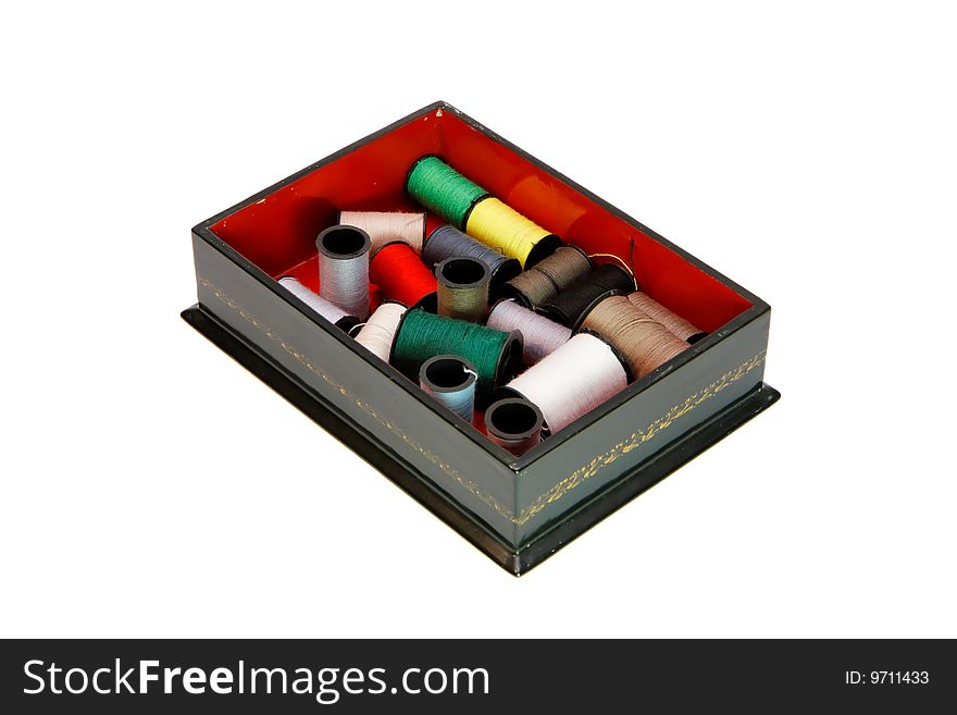 Dark green wooden casket with colorful threads isolated