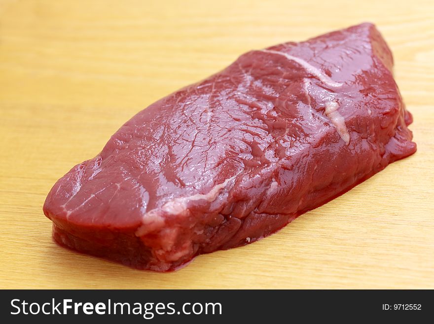 Uncooked Steaks On Wooden Cutting Board