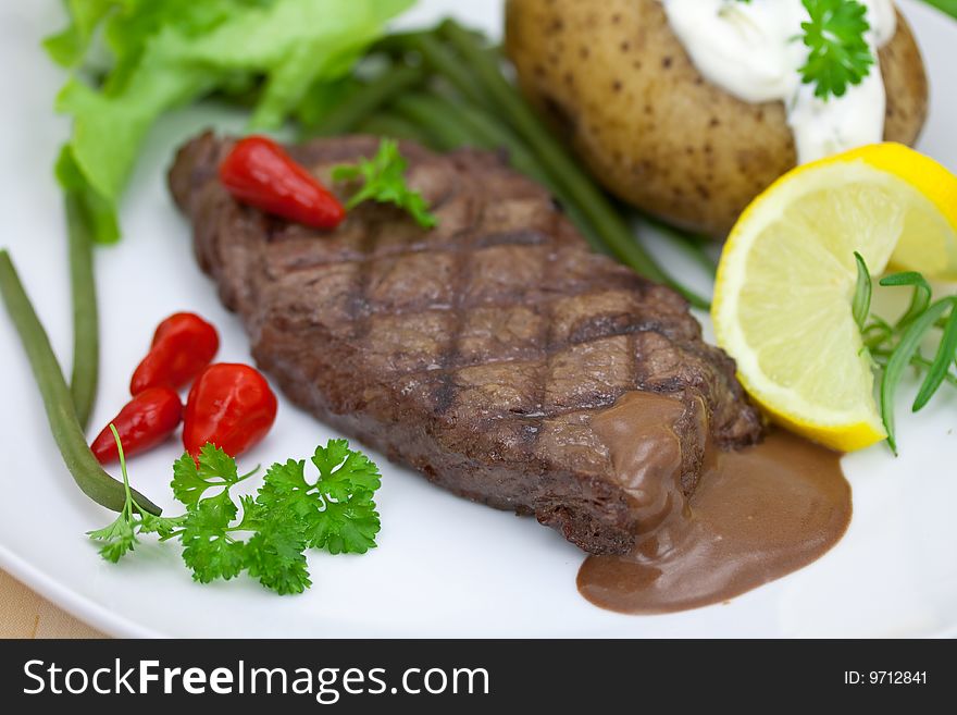 Grilled steak with baked potato and cream