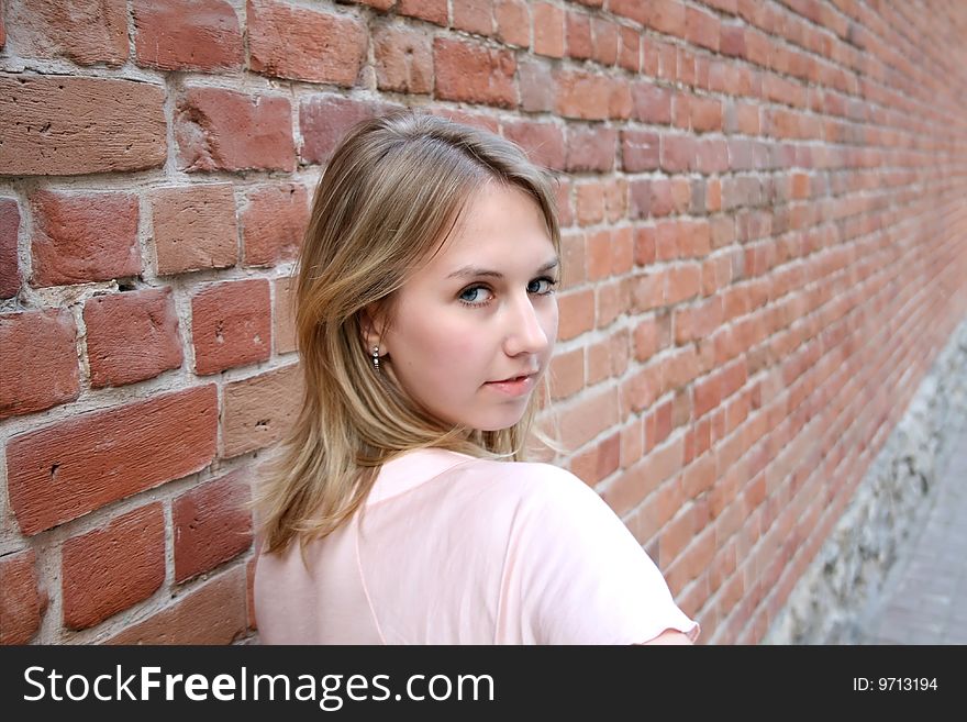 Nice girl near brick wall