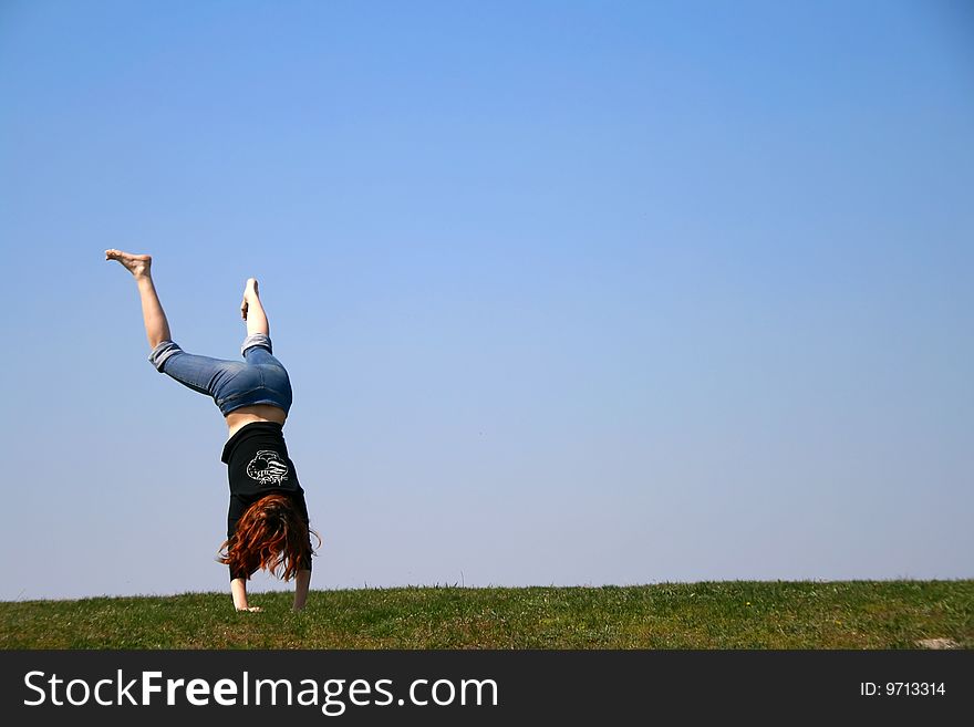 The girl taken in a jump lstanding on the hands. The girl taken in a jump lstanding on the hands