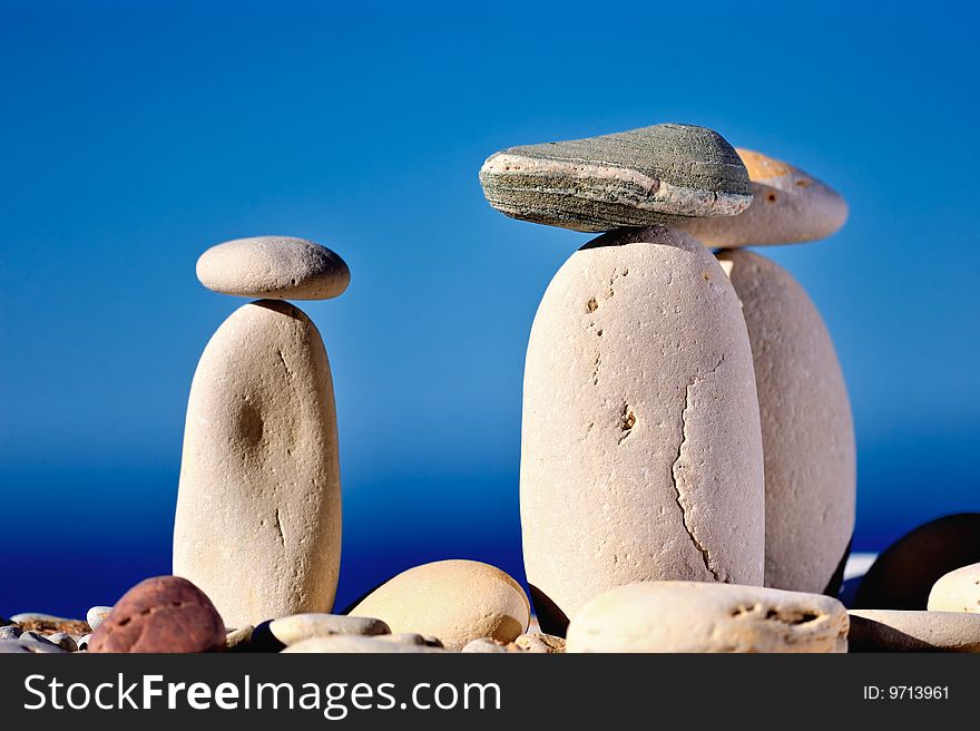 Three long white pebbles on a background of blue sky. Three long white pebbles on a background of blue sky