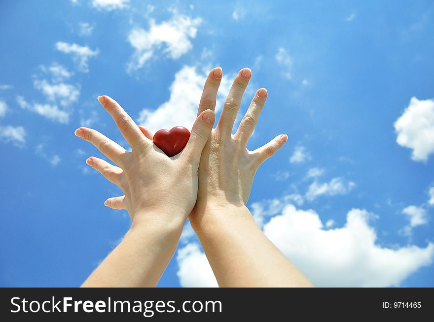 Heart in female hands against the sky. Heart in female hands against the sky