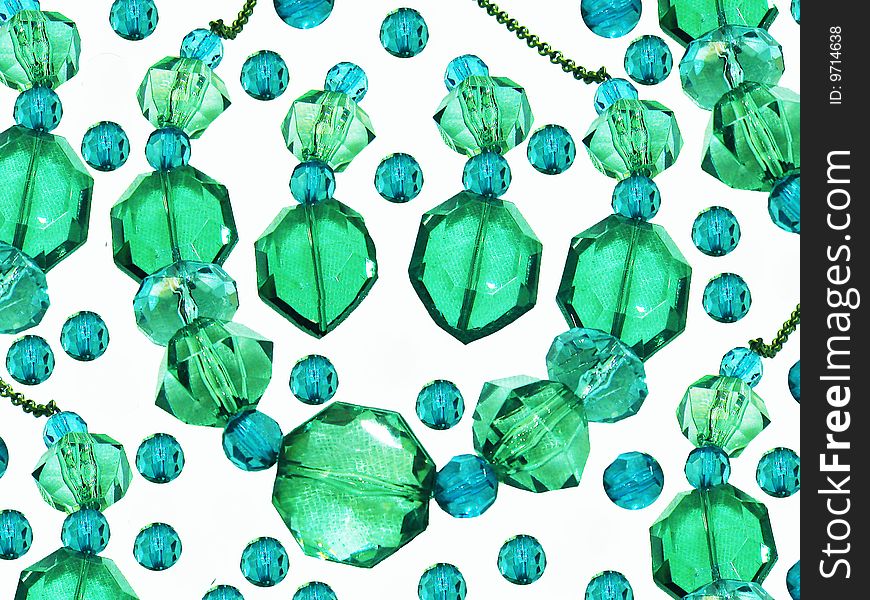 A background of a blue and green gemstone necklace and earrings, with beads surrounding it. A background of a blue and green gemstone necklace and earrings, with beads surrounding it.