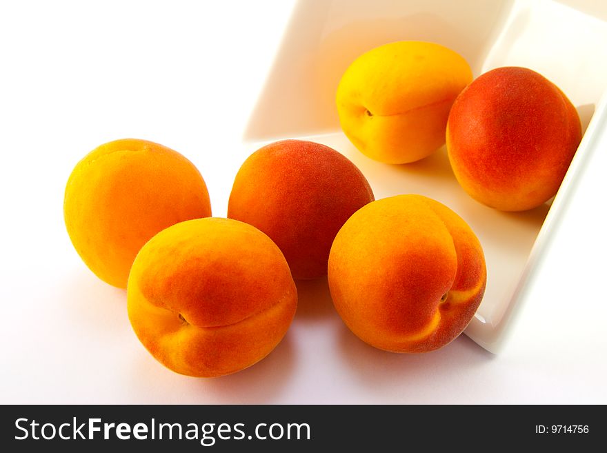 Spilt bowl of apricots with white background with clipping path