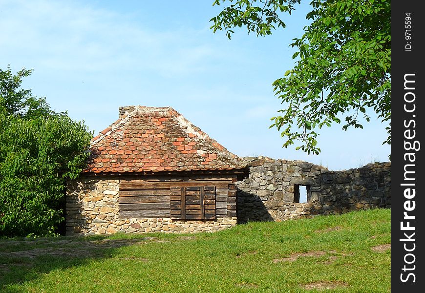 Small ancient house near a medieval fortress wall in Transylvania. Small ancient house near a medieval fortress wall in Transylvania