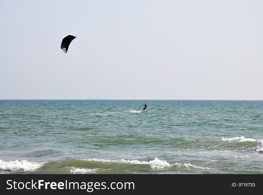 Kitesurfer in black and the sea