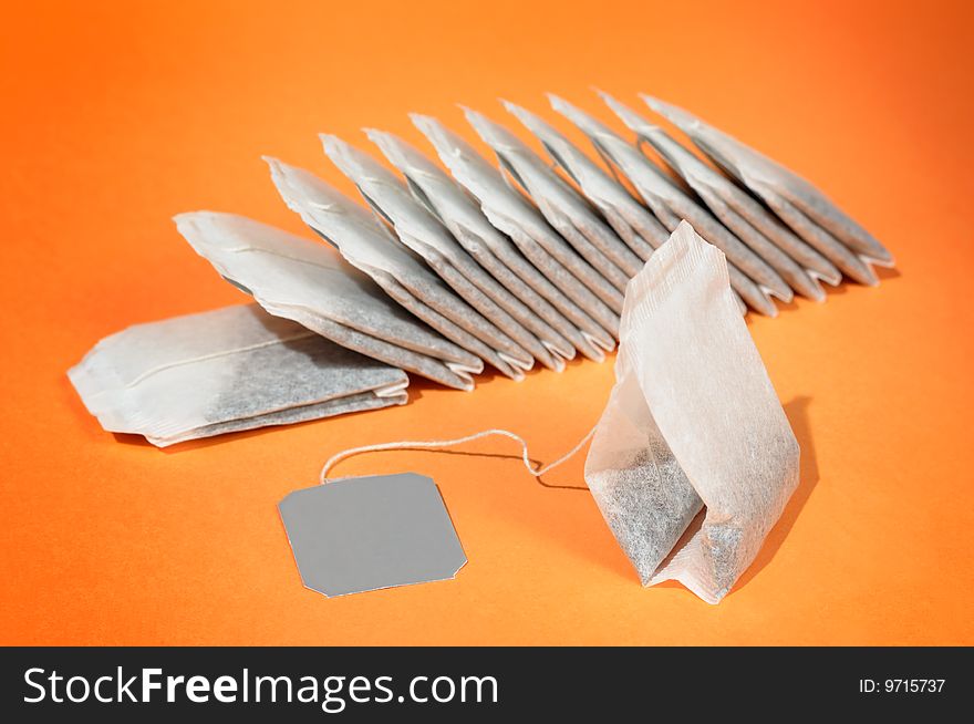 Tea bags against tea color background. Tea bags against tea color background.