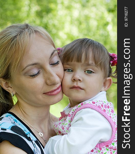 Mother and little daughter tender outdoor portrait
