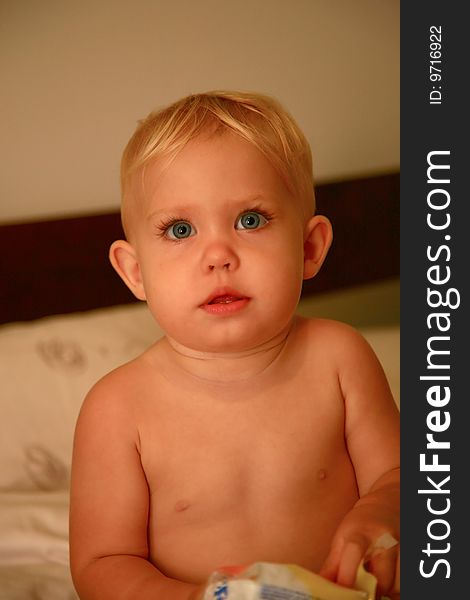 Baby standing in bed after the bath. Baby standing in bed after the bath