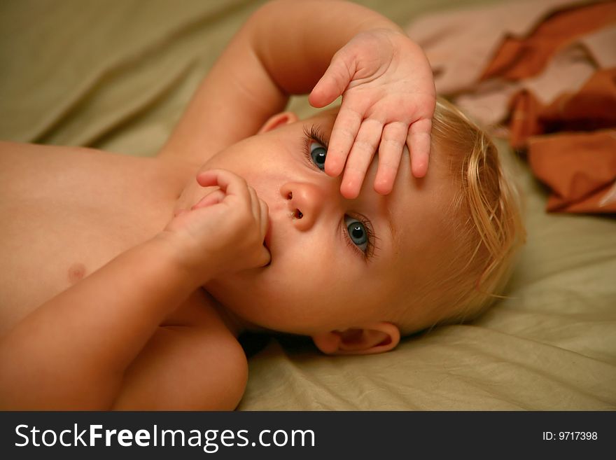 Baby girl hiding behind her hand. Baby girl hiding behind her hand