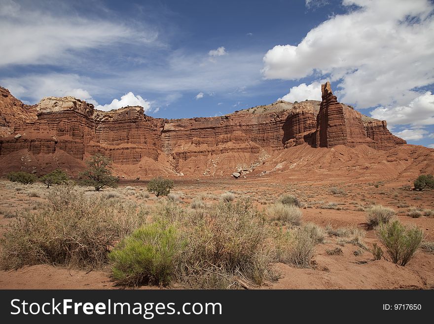 View of red rock formations in Captiol Reef National Park with blue sky�s the and clouds