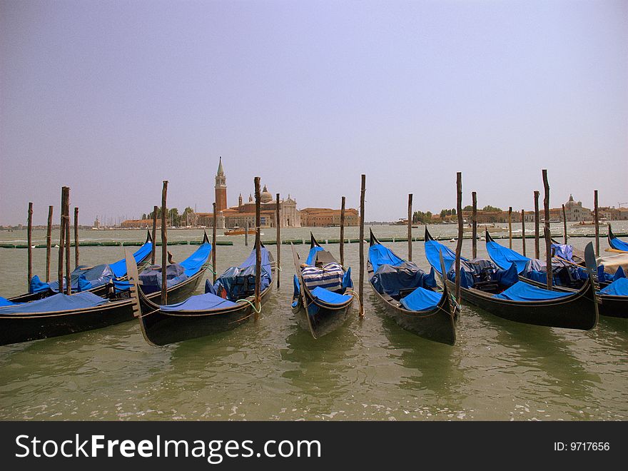 A beautiful shot of a group of gondolas in a summer afternoon light. In the background can be seen the San Giorgio Maggiore and Guidecca, two well known landmarks of Venice. With the gondolas in the front the effect is guaranteed. A beautiful shot of a group of gondolas in a summer afternoon light. In the background can be seen the San Giorgio Maggiore and Guidecca, two well known landmarks of Venice. With the gondolas in the front the effect is guaranteed.