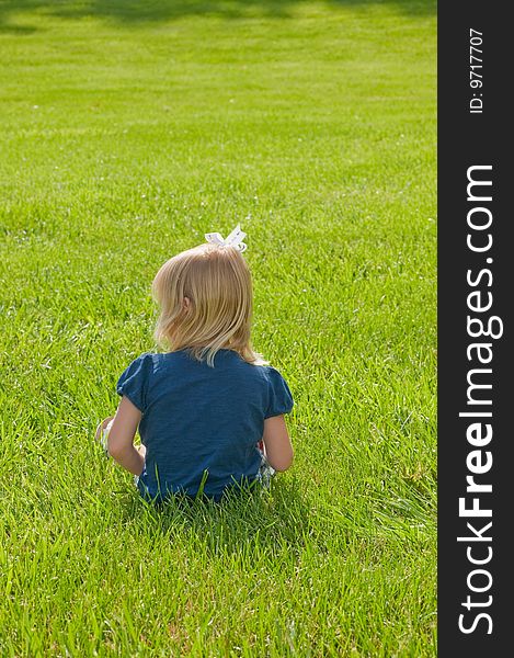 Little Girl Sitting In Grass