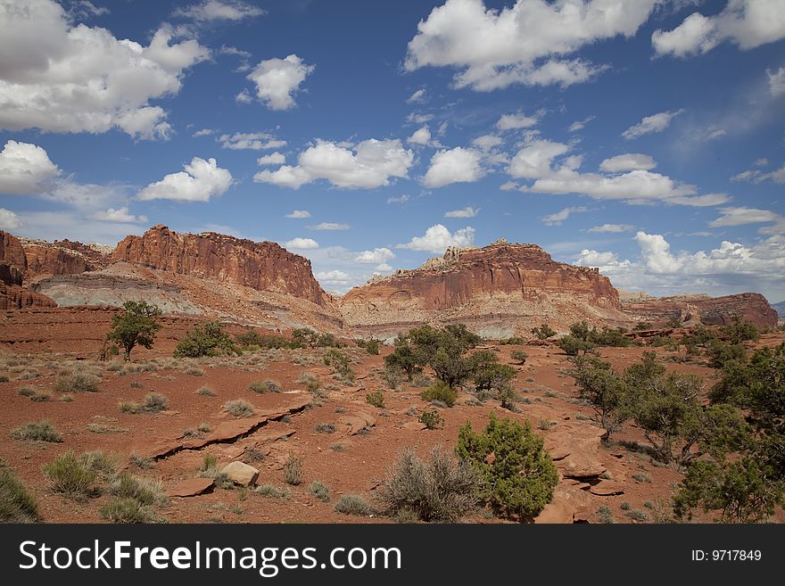 View of red rock formations in Captiol Reef National Park with blue sky�s the and clouds