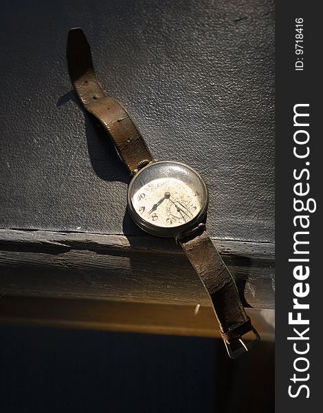 Old hand watch, on old table, leather belt