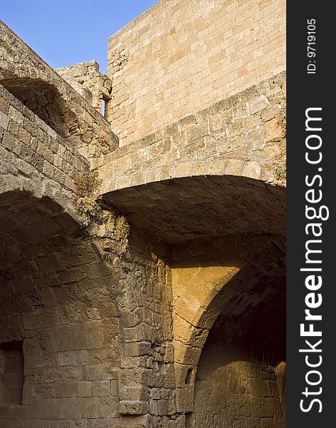 Fortress walls. Arches. A fragment in a fortress.Fortress of monks Ionitov.The city of Lindos. Island Rhodes. Greece. Fortress walls. Arches. A fragment in a fortress.Fortress of monks Ionitov.The city of Lindos. Island Rhodes. Greece.