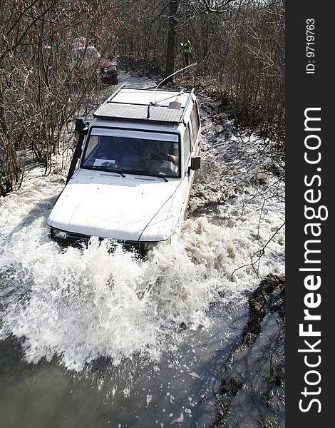 The white car goes on the big  river