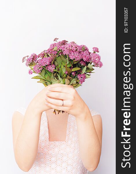 Girl with bunch of pink field flowers