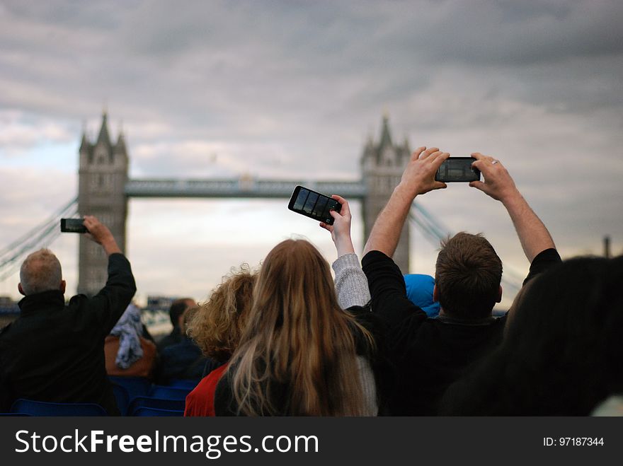 People Taking Picture at Tower Bridge Under Gray Clouds