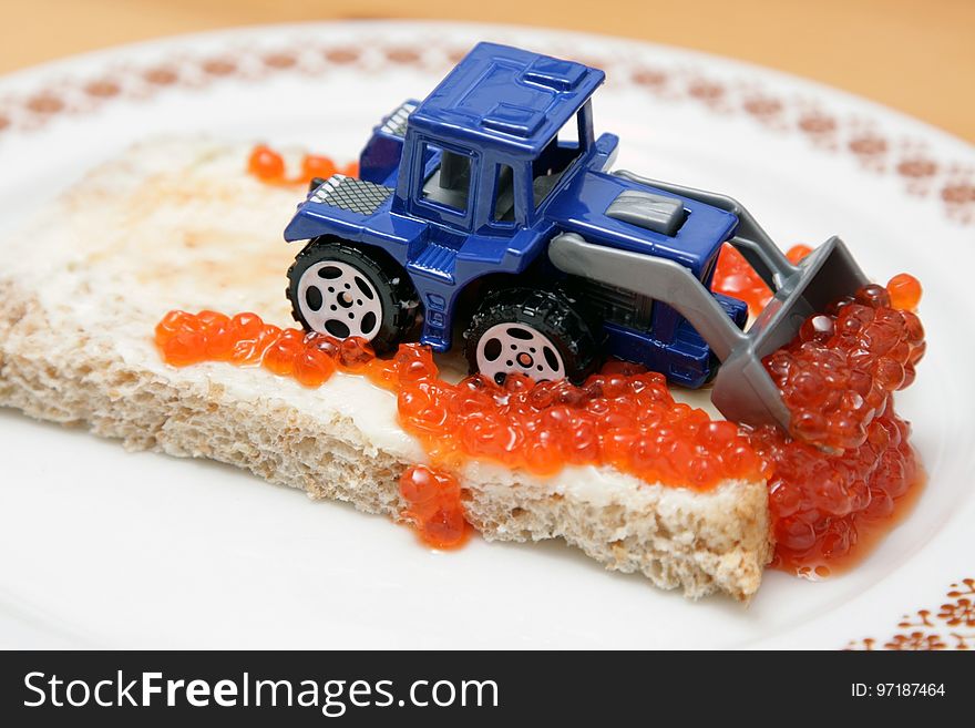 Blue and Gray Excavator on Top of Bread