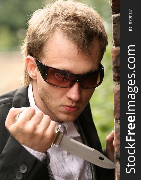 Angry man in sunglasses holding a knife. Angry man in sunglasses holding a knife