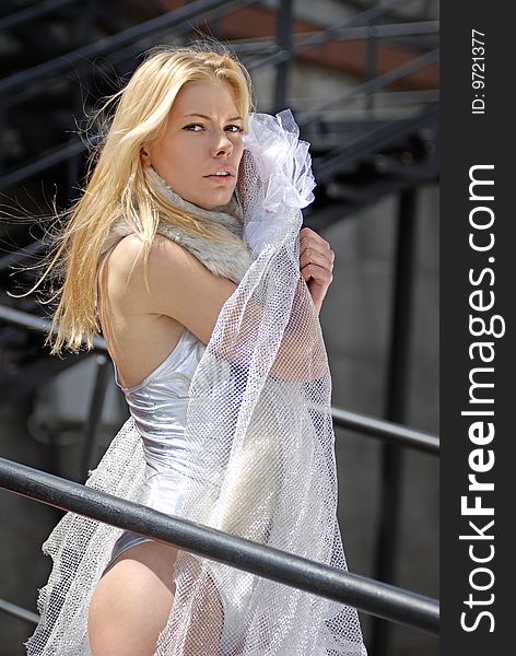 Beautiful blonde fiancee with veil on stairs